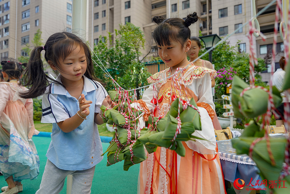 6月19日，浙江省丽水经济技术开发区南城实验幼儿园的孩子们挂起制作好的粽子。人民网 章勇涛摄