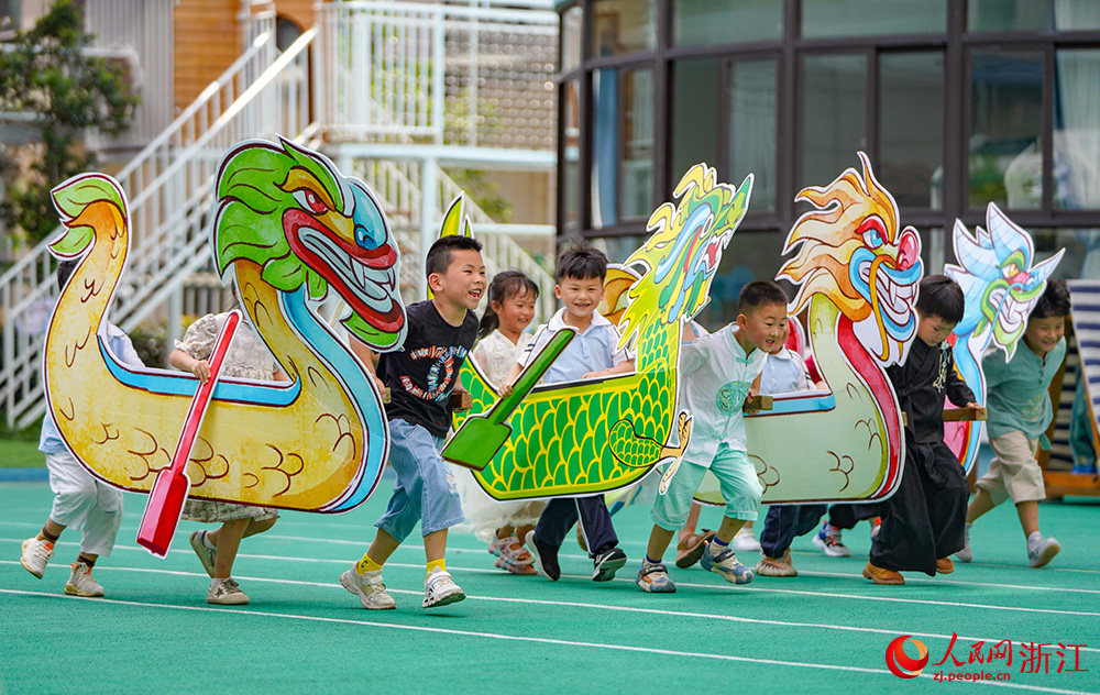 6月19日，浙江省丽水经济技术开发区南城实验幼儿园的孩子们在划旱地龙舟。人民网 章勇涛摄