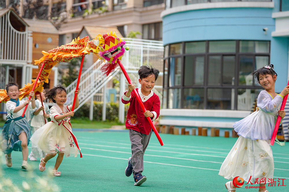 6月19日，浙江省丽水经济技术开发区南城实验幼儿园的孩子们在舞龙。人民网 章勇涛摄