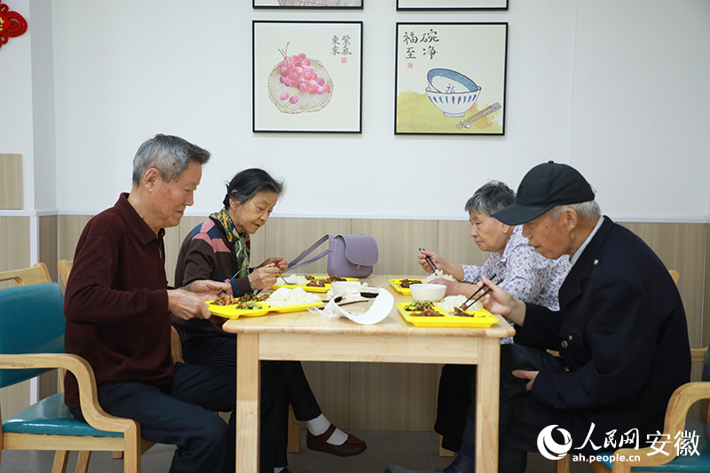 陈桂兰（左二）和老伴在助餐点就餐。人民网记者 陶涛摄