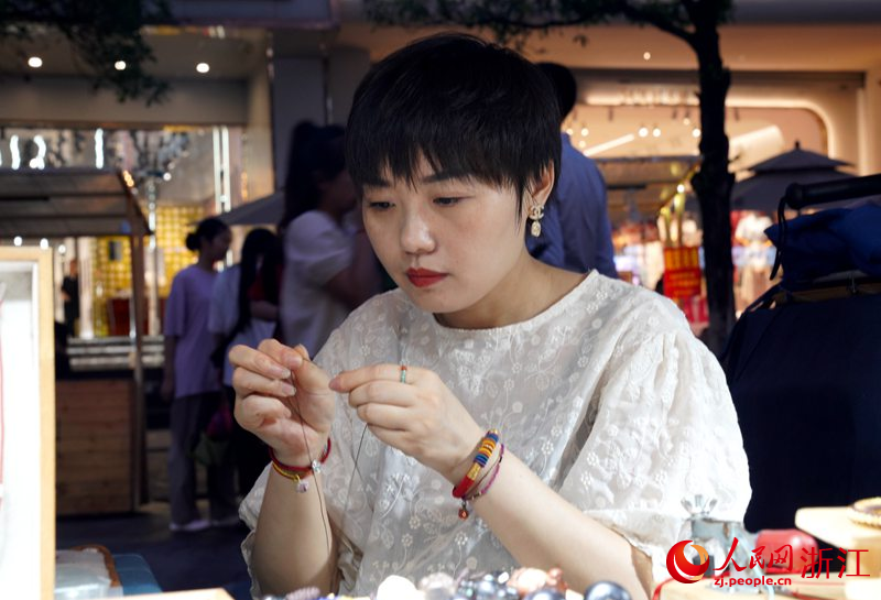 刘小庆正在编绳。人民网 陈陆洵摄