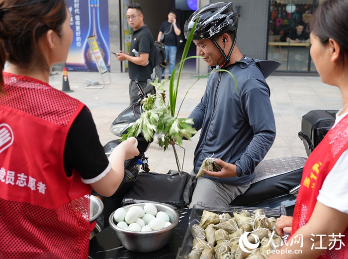 端午节当天，晓庄“宁小蜂”驿站向外卖小哥赠送粽子和艾草。人民网记者 马晓波摄