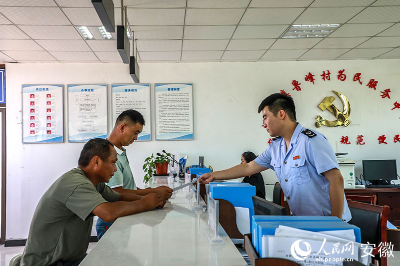 税务局工作人员给村民递交办税服务材料。人民网记者 陶涛摄