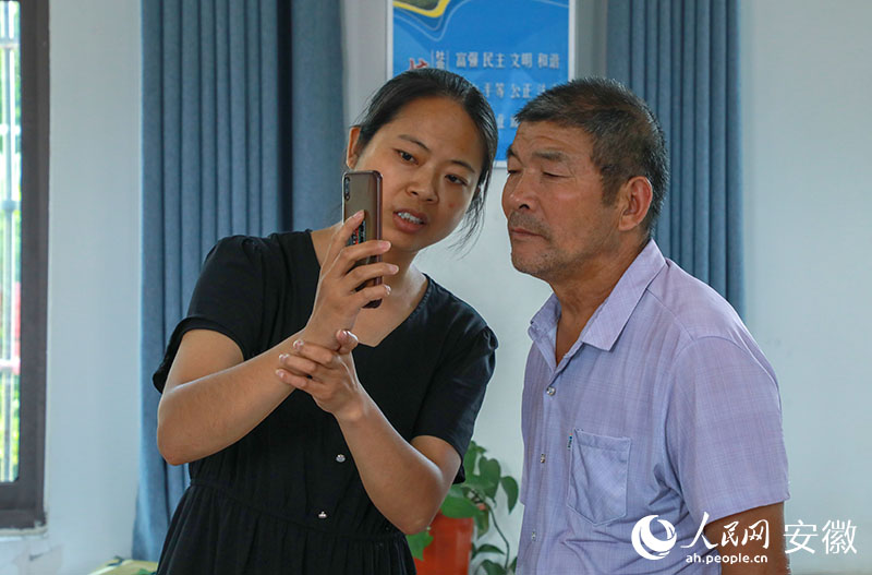 王明鳳給村民介紹辦稅服務。人民網記者 陶濤攝