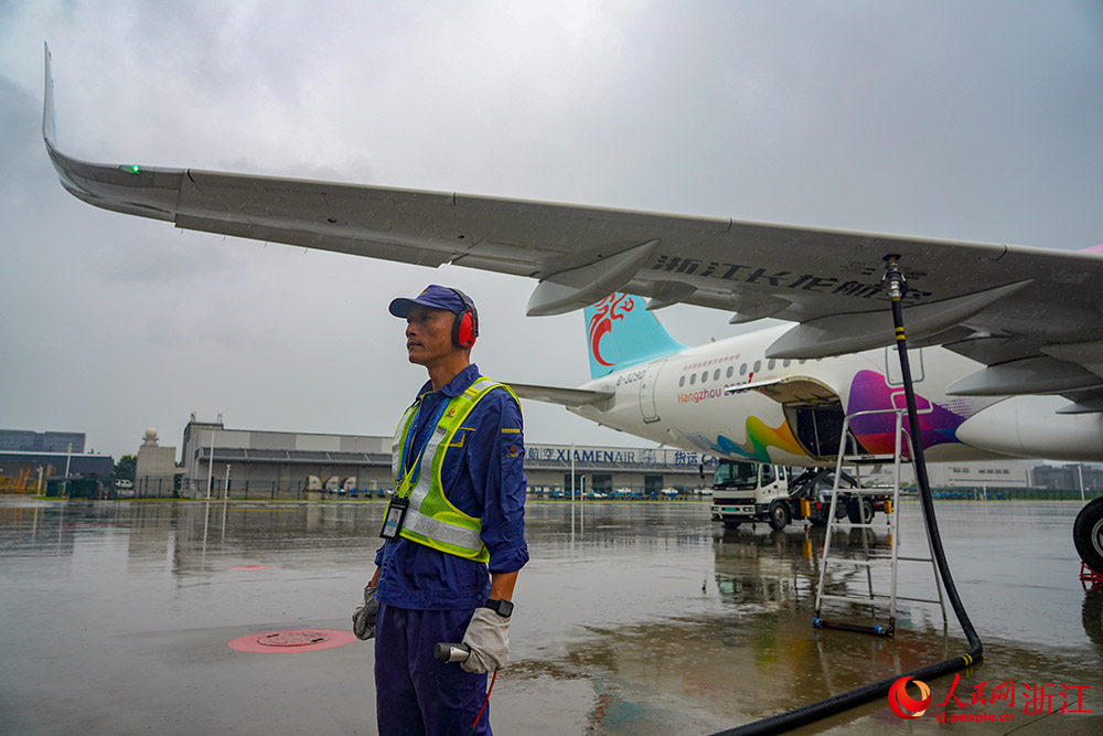 9月13日，在杭州蕭山國際機場停機坪，加油員手持控制器，對亞運航班進行生物航煤加注。人民網 章勇濤攝