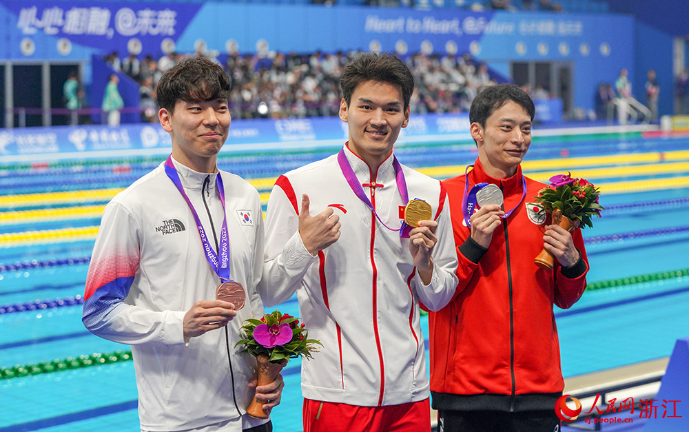 9月24日，杭州亚运会游泳项目开赛，中国队选手徐嘉余（中）夺得男子100米仰泳冠军。人民网 章勇涛摄