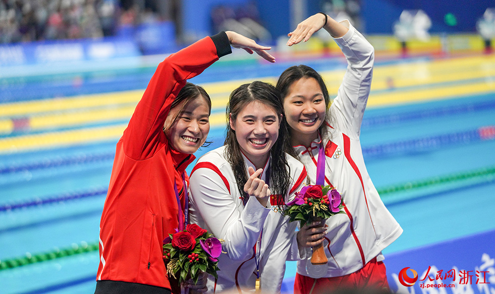9月24日，杭州亚运会游泳项目开赛，中国队选手张雨霏（中）夺得女子200米蝶泳冠军。人民网 章勇涛摄