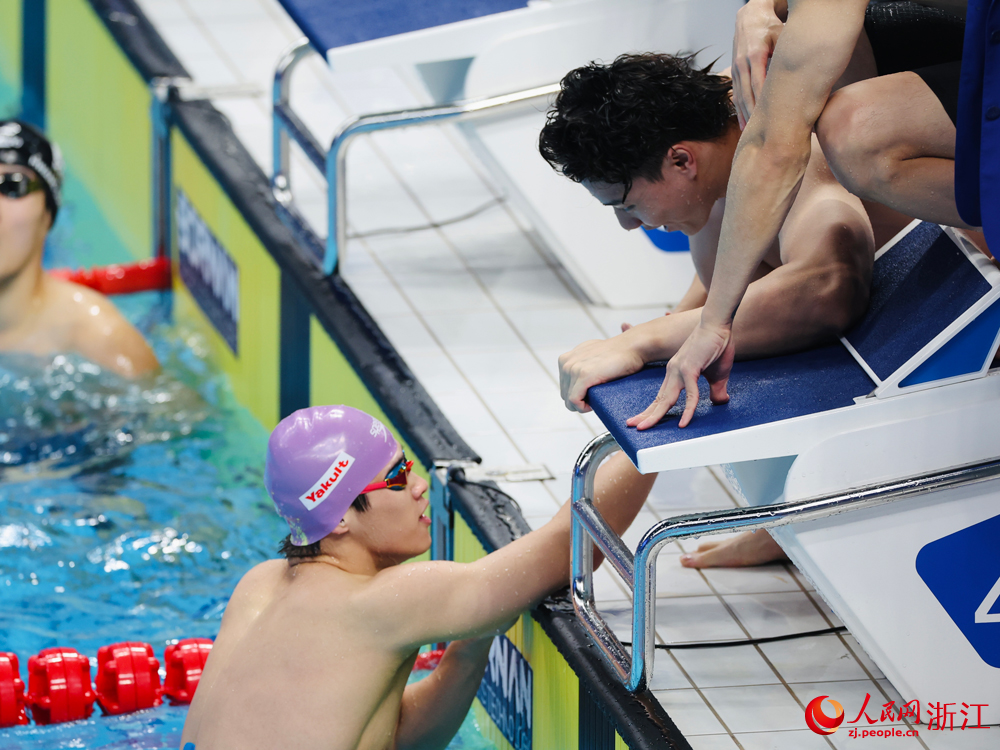 取得4×100米比赛冠军后，潘展乐与队友庆祝。人民网 陈陆洵摄