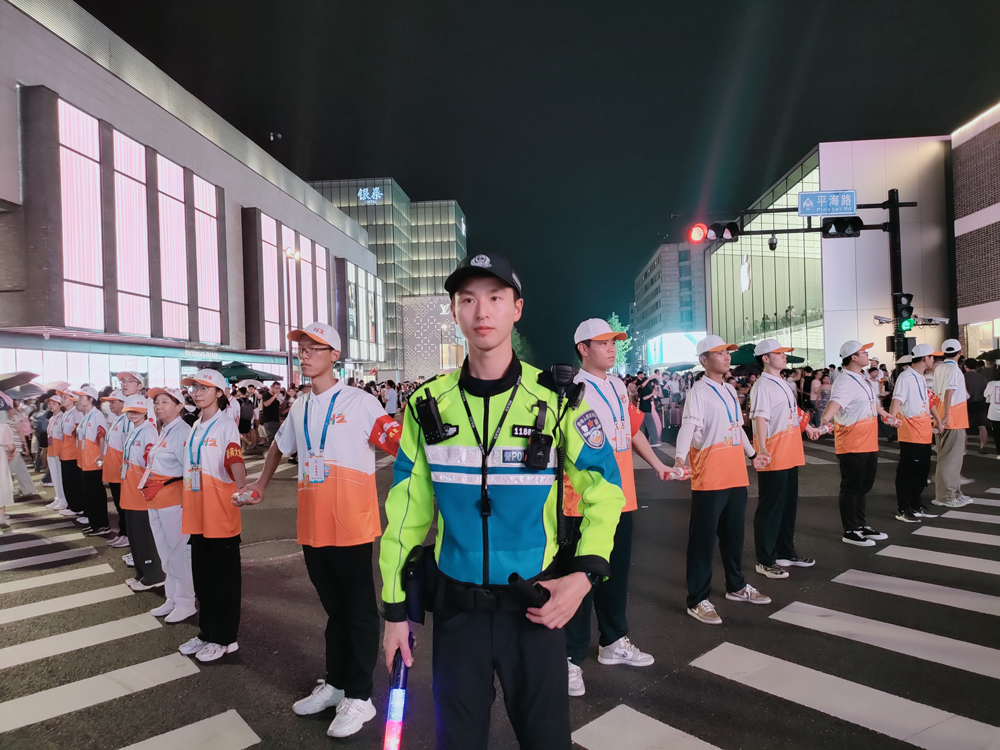 志愿者手拉手筑成一道人墙，帮助交警管控人流。湖滨街道供图