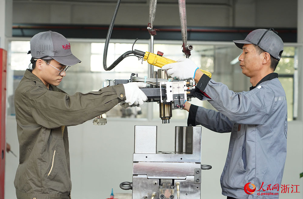 在台州科技职业学院凯华模具产业学院，学生（左）在吊装模具。人民网 章勇涛摄