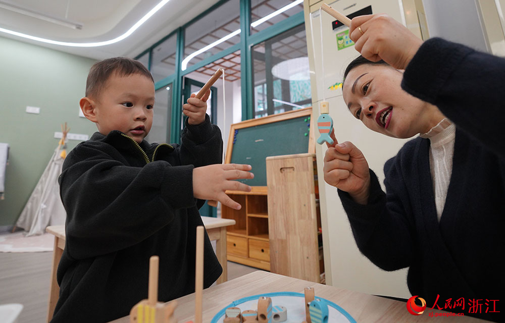 11月16日，在宁波市镇海宝山幼儿园，小朋友在园内和老师一起玩耍。人民网 章勇涛摄