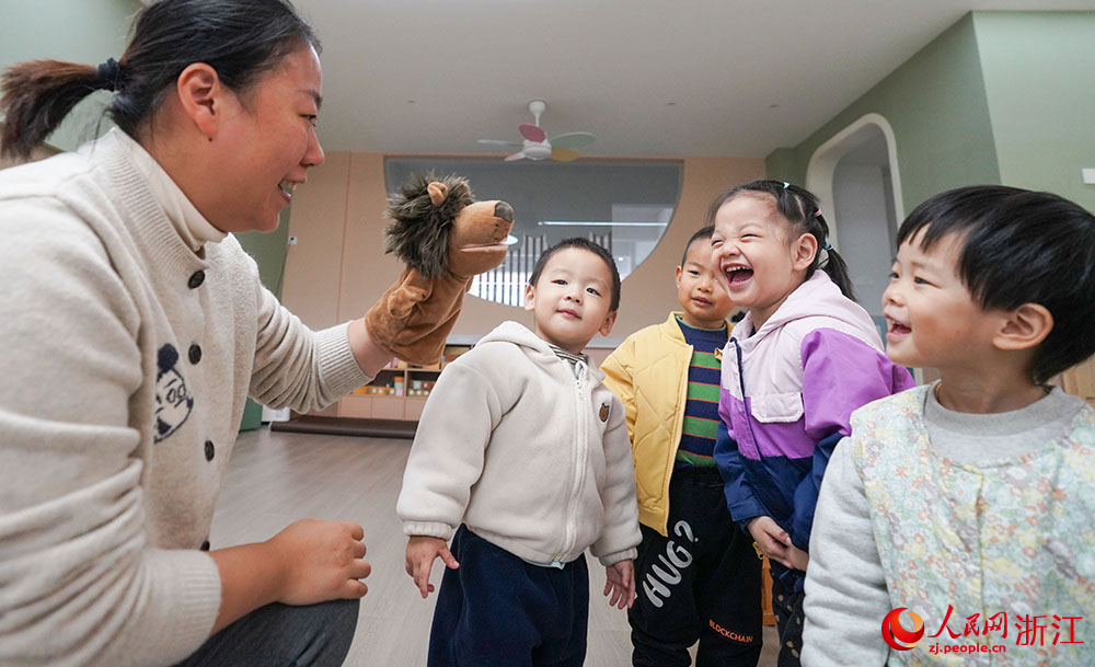 11月16日，在宁波市镇海宝山幼儿园，小朋友在园内和老师一起玩耍。人民网 章勇涛摄