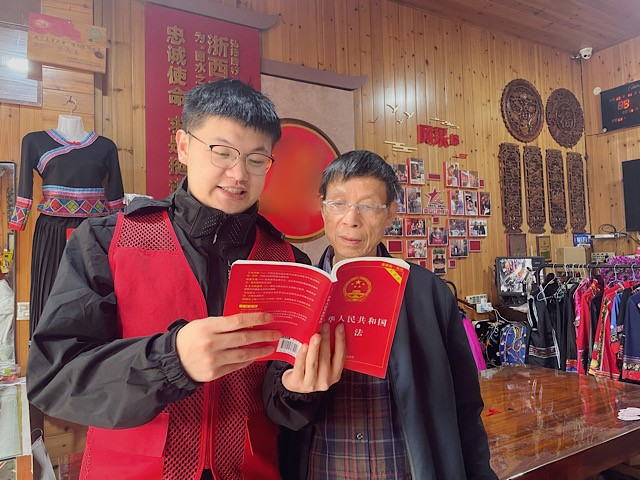 “香溢”志愿者（左）向零售户讲解《宪法》知识。吕荣智摄