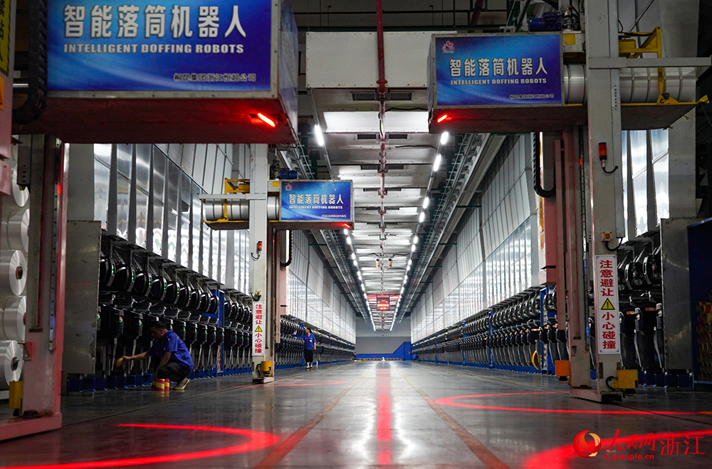 在浙江省桐乡市桐昆集团聚酯纤维“未来工厂”，各类自动化设备和5G机器人有序运转。人民网 章勇涛摄
