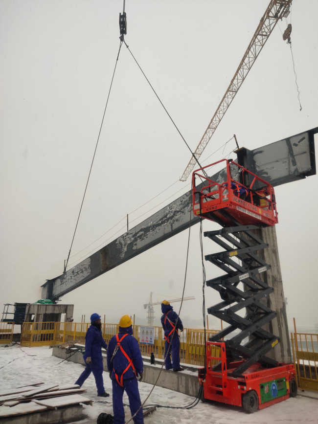 施工人员在雪天开展站房钢结构主钢梁吊装施工