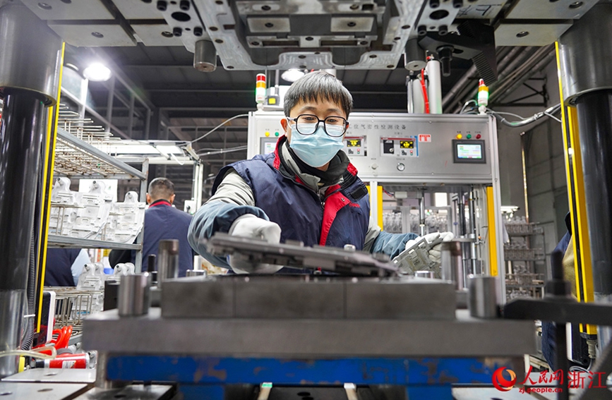 台州市天台县一汽车零部件企业车间，工人在智能化设备的协助下赶制订单。人民网 章勇涛摄