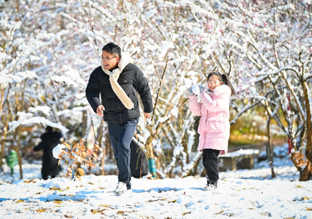 市民走出家门，欣赏难得的雪景。朱伟摄
