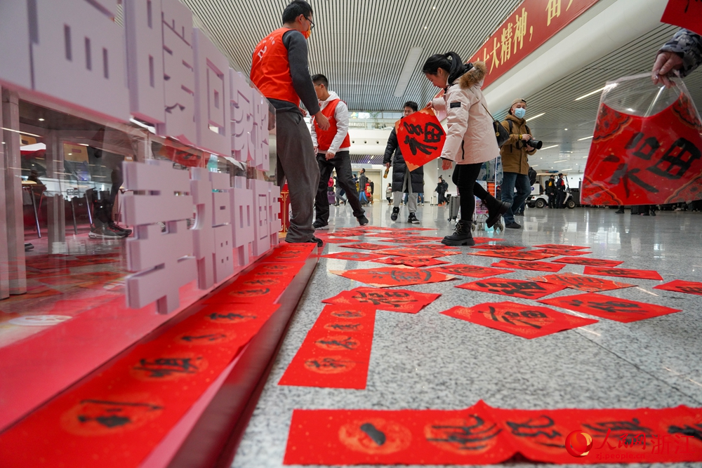 1月26日，杭州東站內，志願者為旅客送上新春祝福。人民網 章勇濤攝