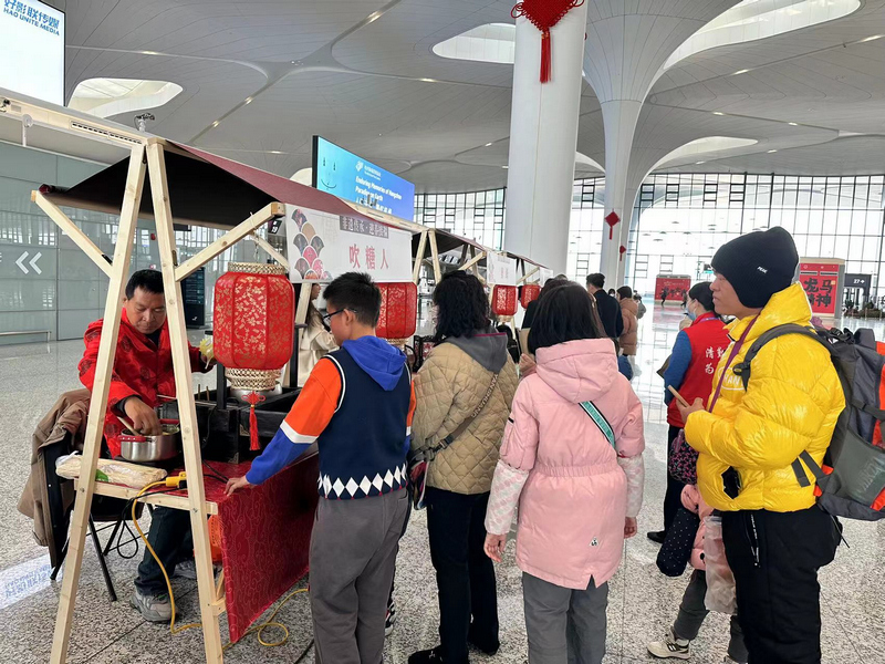 在杭州蕭山機場，旅客參與吹糖人活動。徐明昊攝
