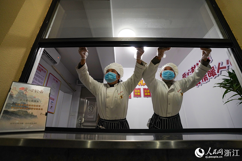 在浙江省慈溪市觀海衛鎮，工作人員開窗准備發放愛心早餐。人民網 章勇濤攝