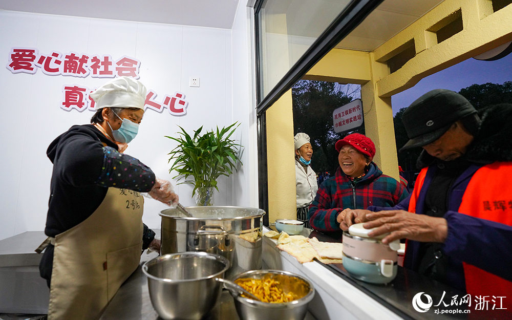 在浙江省慈溪市觀海衛鎮，環衛工人領取愛心早餐。人民網 章勇濤攝