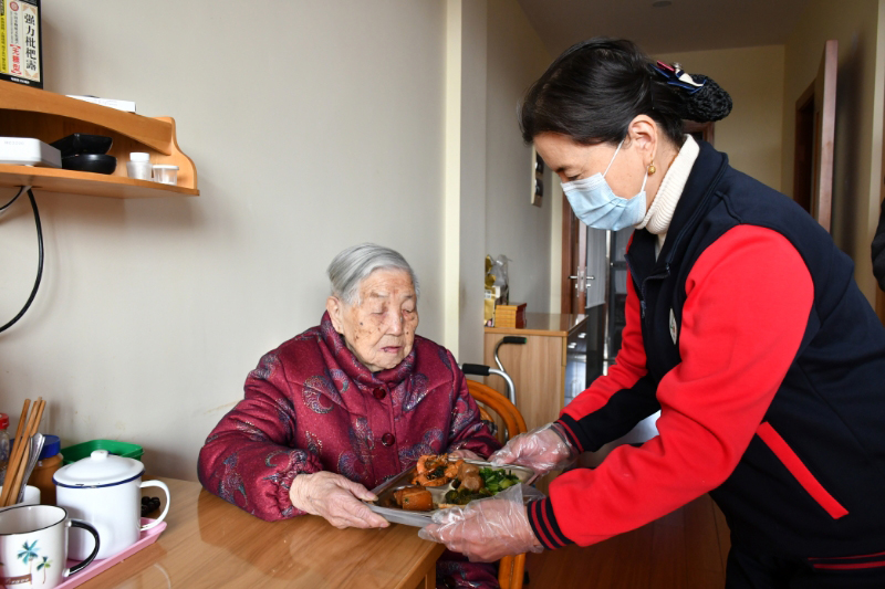 护理员为老人送餐。