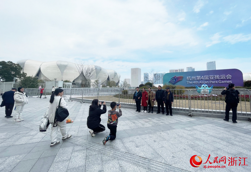 大年初四，不少市民来到杭州奥体中心，在亚运会标牌前合影留念。人民网记者 王丽玮摄