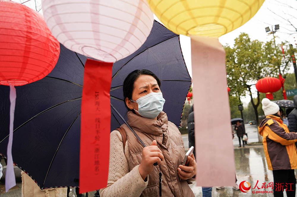 市民游客在杭州市拱墅区石桥街道广场里猜灯谜。人民网 章勇涛摄