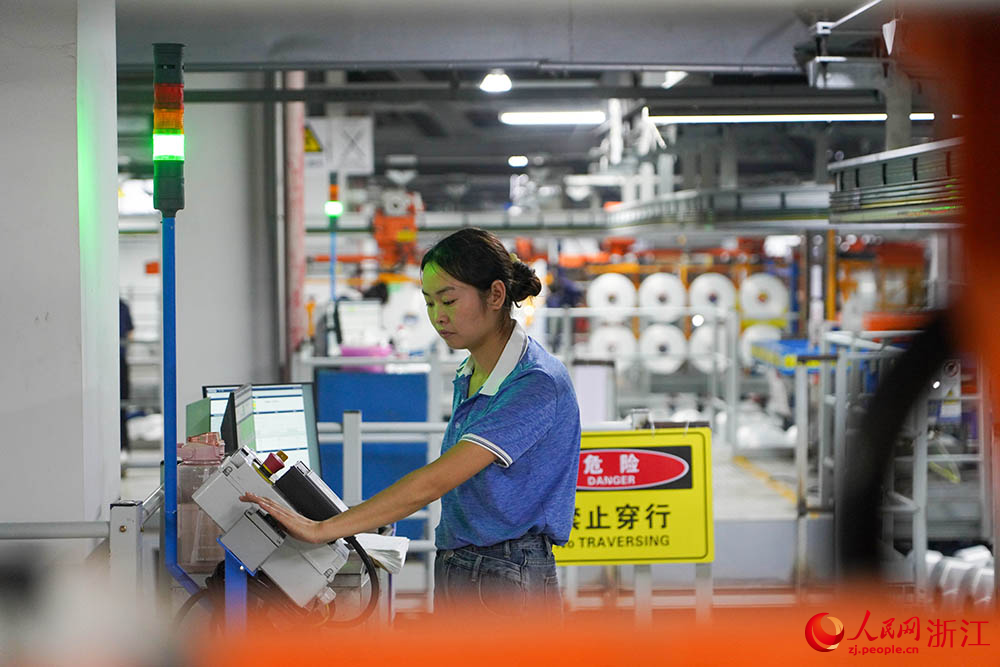 在浙江省紹興市柯橋區的一家化纖企業，工人在生產線上作業。人民網 章勇濤攝