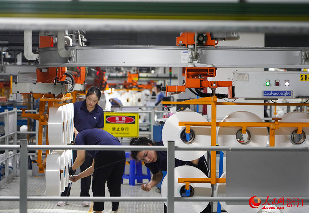 在浙江省紹興市柯橋區的一家化纖企業，工人在生產線上作業。人民網 章勇濤攝