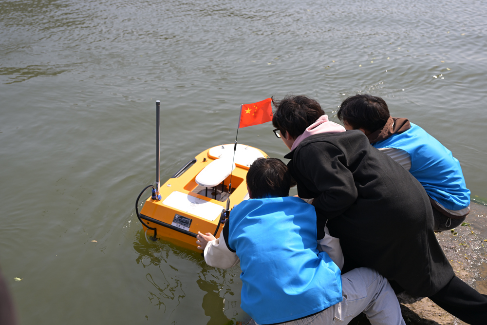 浙江水院信息工程学院的学生志愿者在南浔古镇用无人船巡河。浙江水院供图