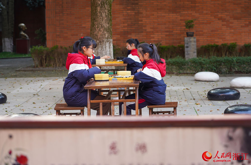 在寧波市江北區慈城鎮中城小學，學生坐棋盤前執子對弈。人民網 章勇濤攝