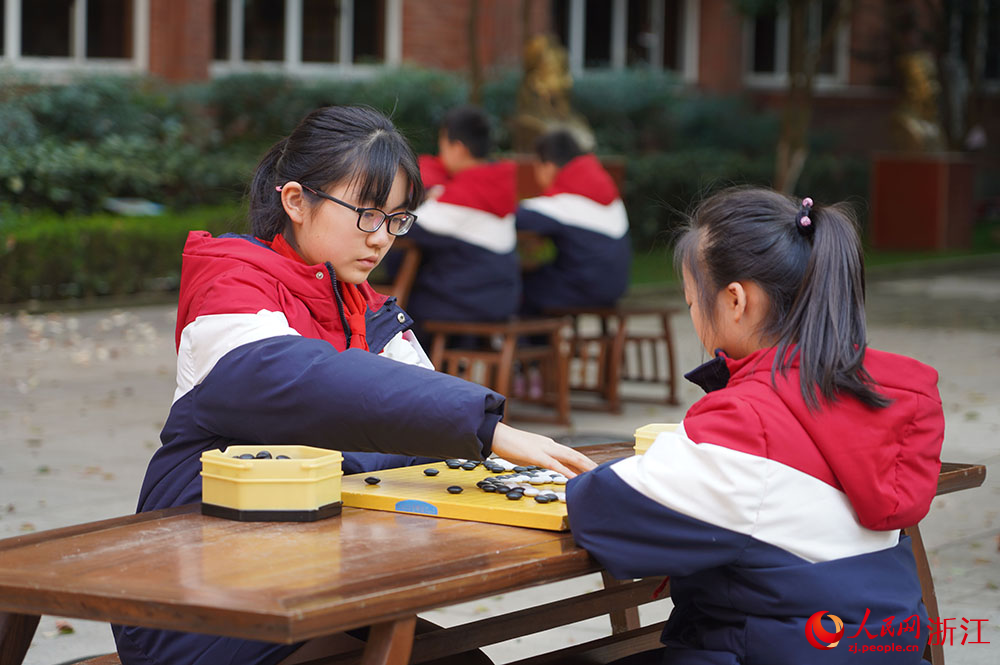 在寧波市江北區慈城鎮中城小學，學生坐棋盤前執子對弈。人民網 章勇濤攝