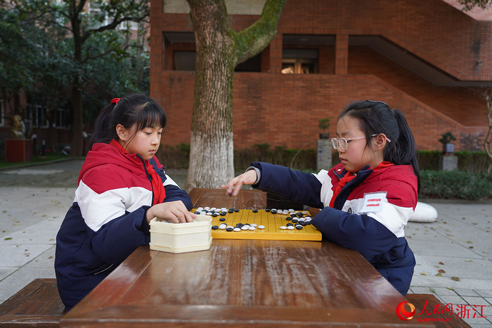 在寧波市江北區慈城鎮中城小學，學生坐棋盤前執子對弈。人民網 章勇濤攝