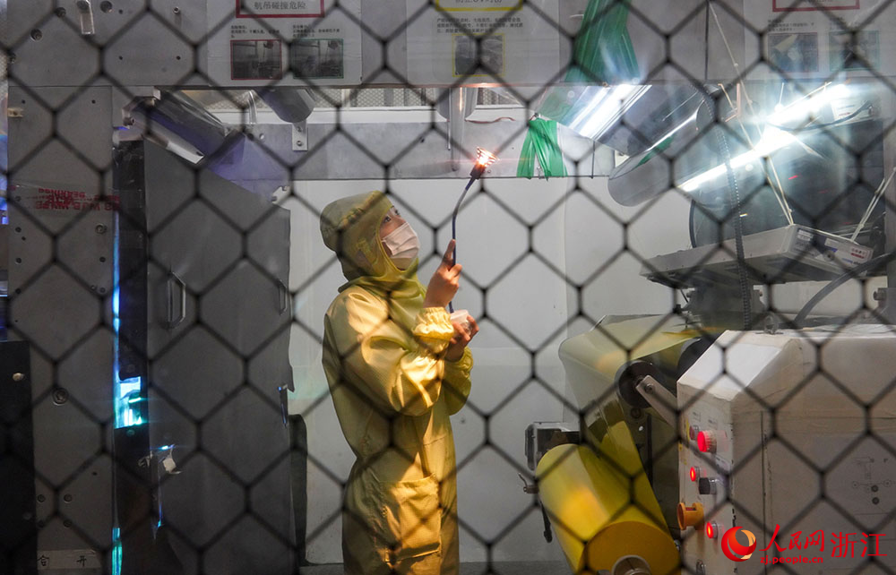 在宁波市江北区一光学膜生产车间内，工人在产线上忙碌着。人民网 章勇涛摄