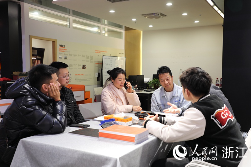 陈燕贞（左三）正与客商面对面洽谈。人民网 方彭依梦摄
