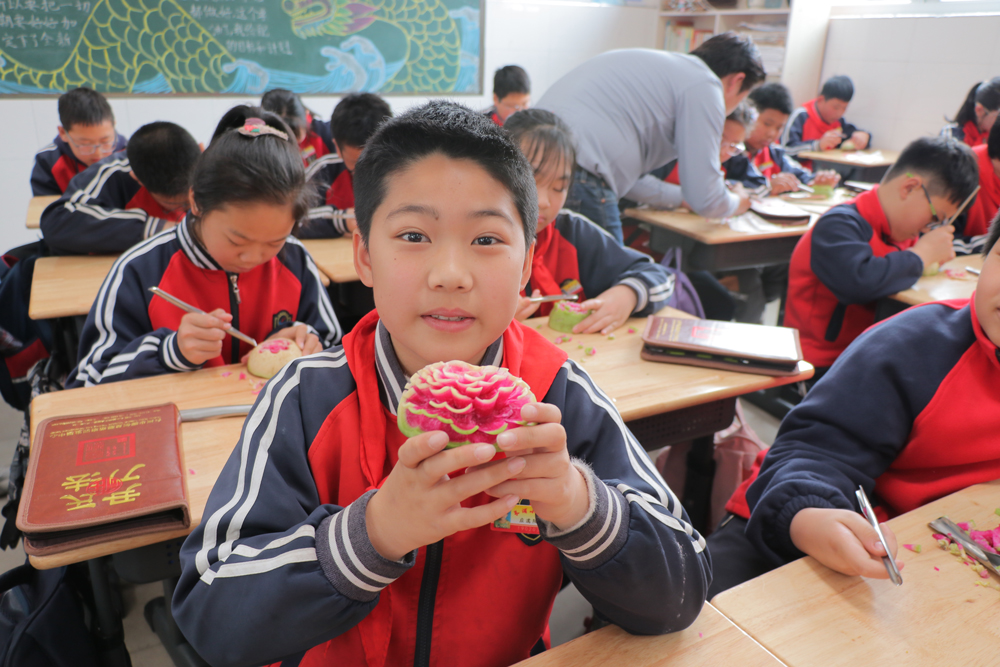 学生们在非遗传人的指导下，近距离接触非遗技艺。徐蒙摄