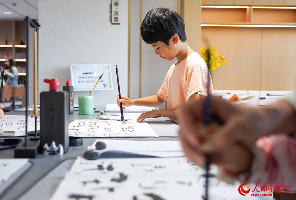 在湖州市南太湖新區桃源未來社區，青少年在練習書法。人民網 章勇濤攝