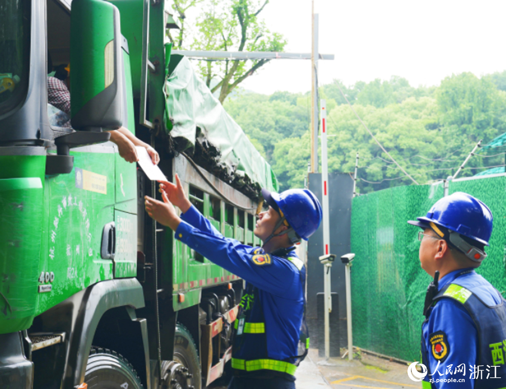 杭州西湖風景名勝區綜合行政執法隊隊員檢查渣土車是否辦理准運証。人民網 劉欣蔚攝