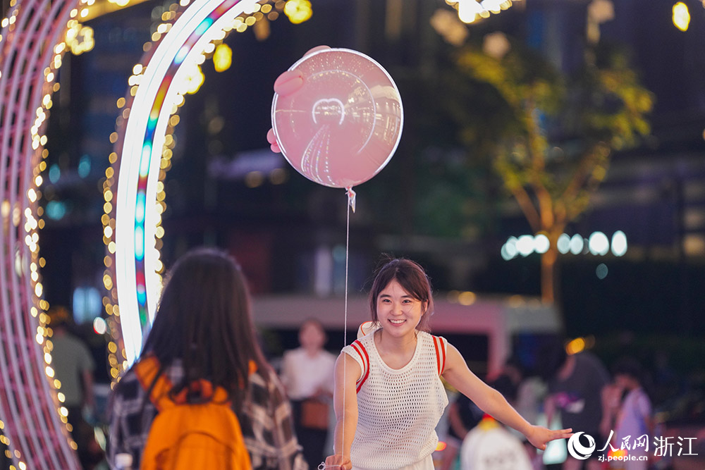 5月25日，杭州武林夜市灯光秀吸引游客驻足，拍照打卡留念。人民网 章勇涛摄