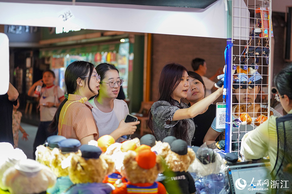 5月25日，在杭州武林夜市上，杭州公安推出的文创产品“警察小熊”吸引游客驻足。人民网 章勇涛摄