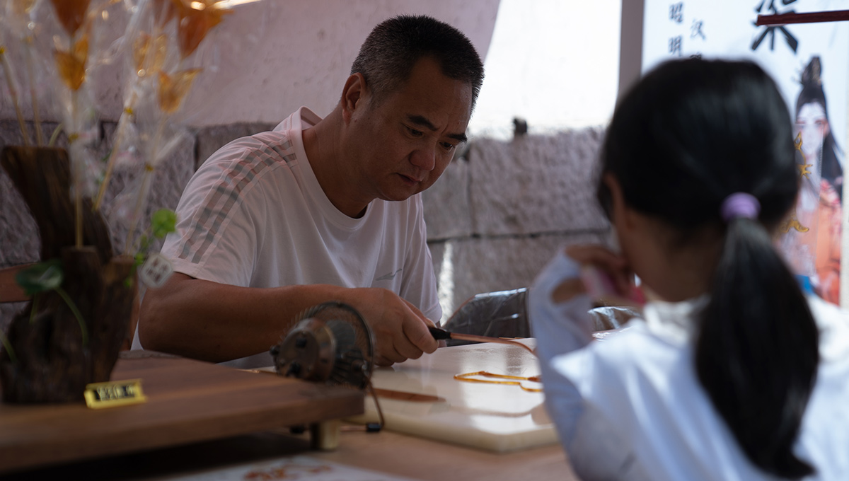 5月26日，在浙江省嘉興市月河街的一家店鋪內，師傅正在為客人制作糖人。人民網 陳陸洵攝