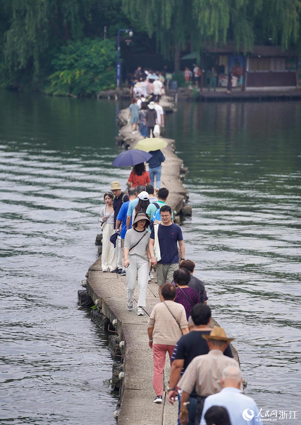 6月9日，游客漫步在浙江省绍兴市柯桥区鉴湖旅游度假区古纤道上。人民网 章勇涛摄