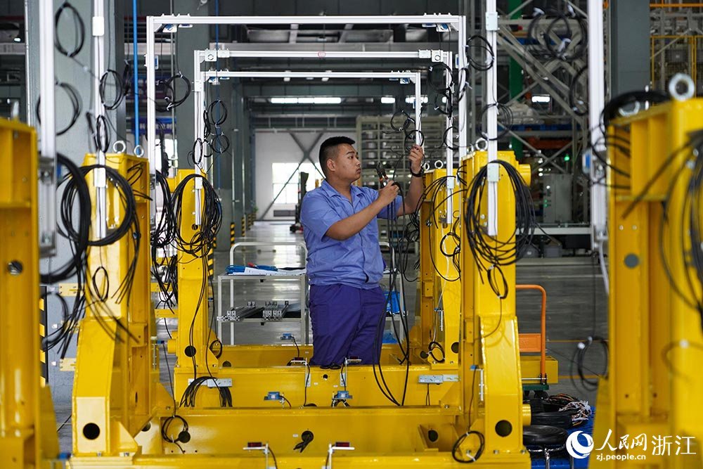 在杭州青山湖科技城的一家叉车企业内，工人在生产线上忙碌着。人民网 章勇涛摄