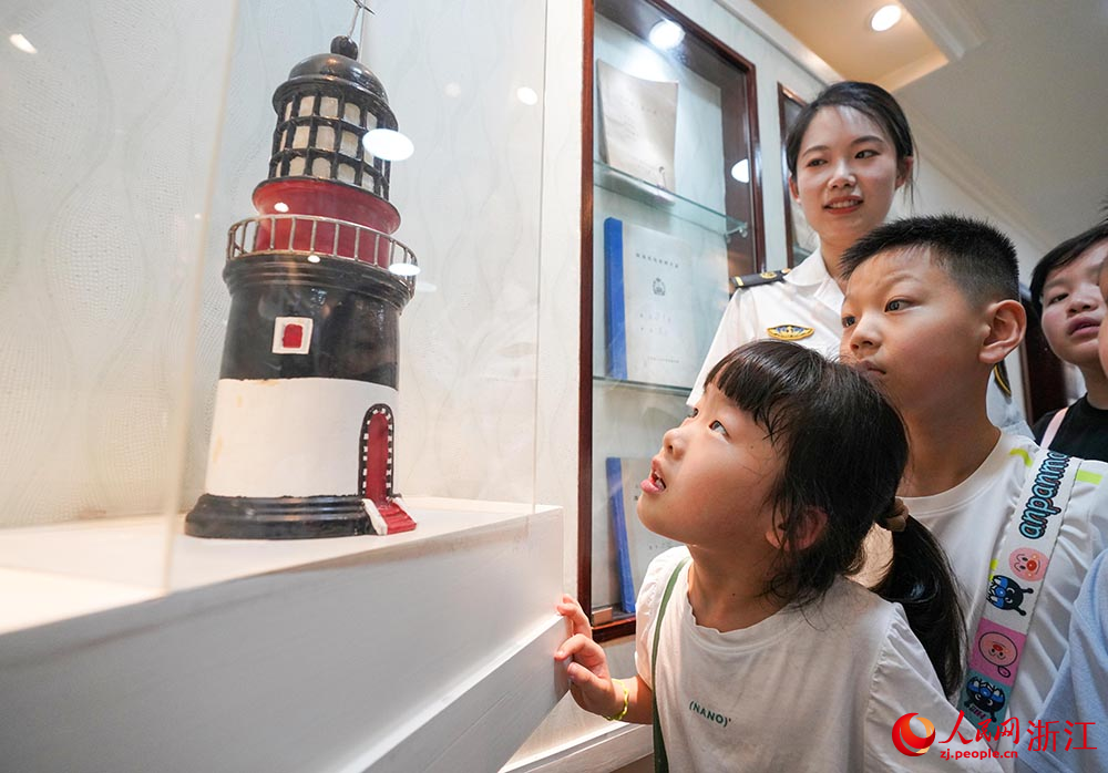 7月11日，“小候鸟”在宁波航标处参观灯塔模型。人民网 章勇涛摄