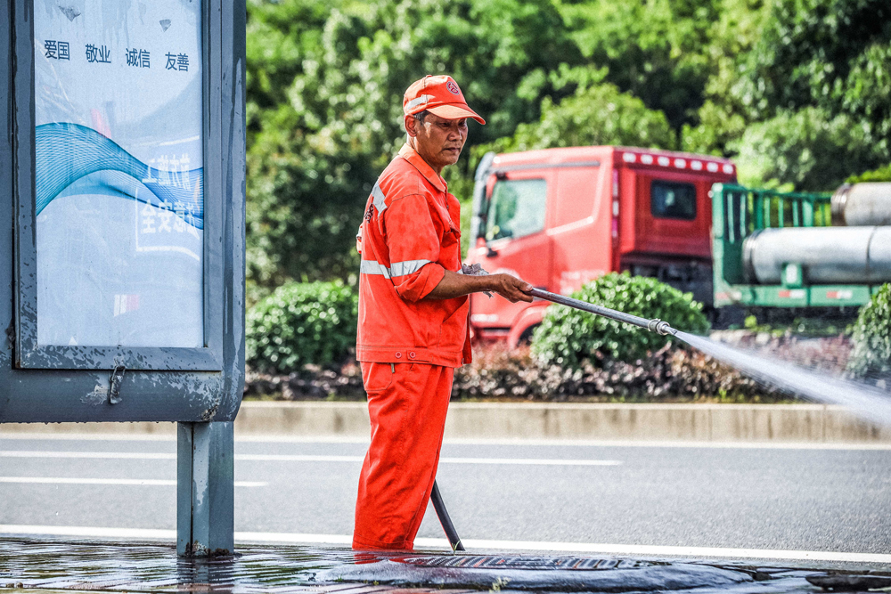 为保障“升温”的道路整体卫生，洗扫工人连续作业，奋战在高温第一线。余杭区交通运输局供图