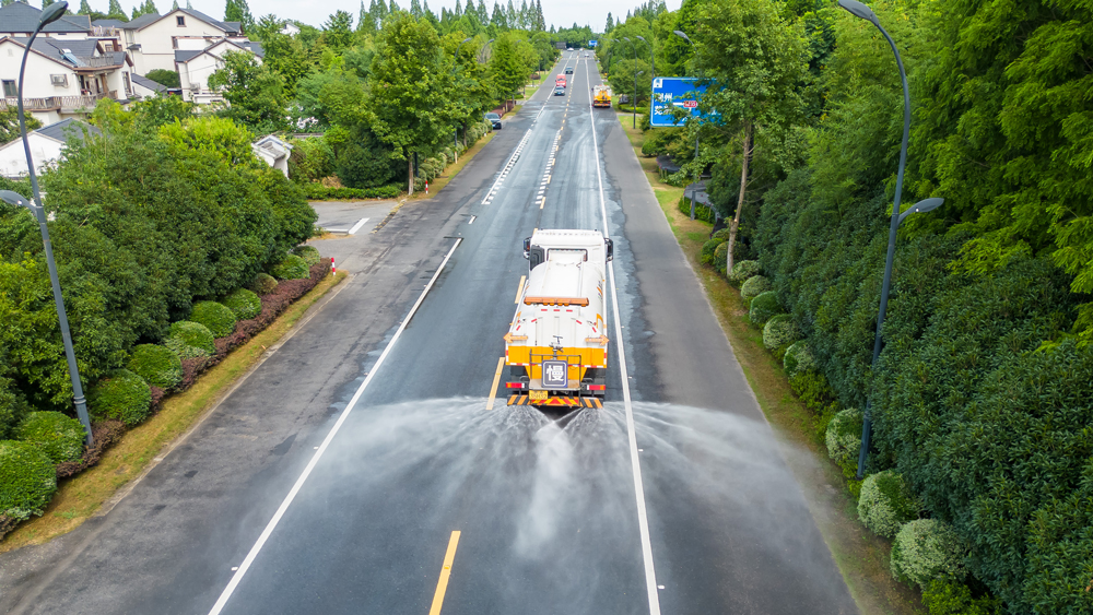 伴随高温，漕雅线一辆辆洒水车在路上穿梭，所过之处，道路见黑，带来一阵阵清凉。余杭区交通运输局供图