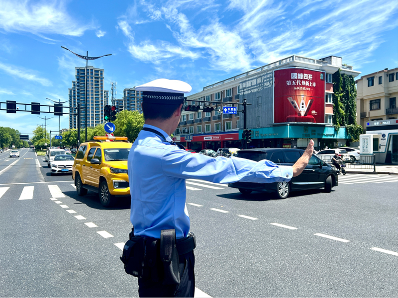 交警頭頂烈日指揮交通。邢潔攝