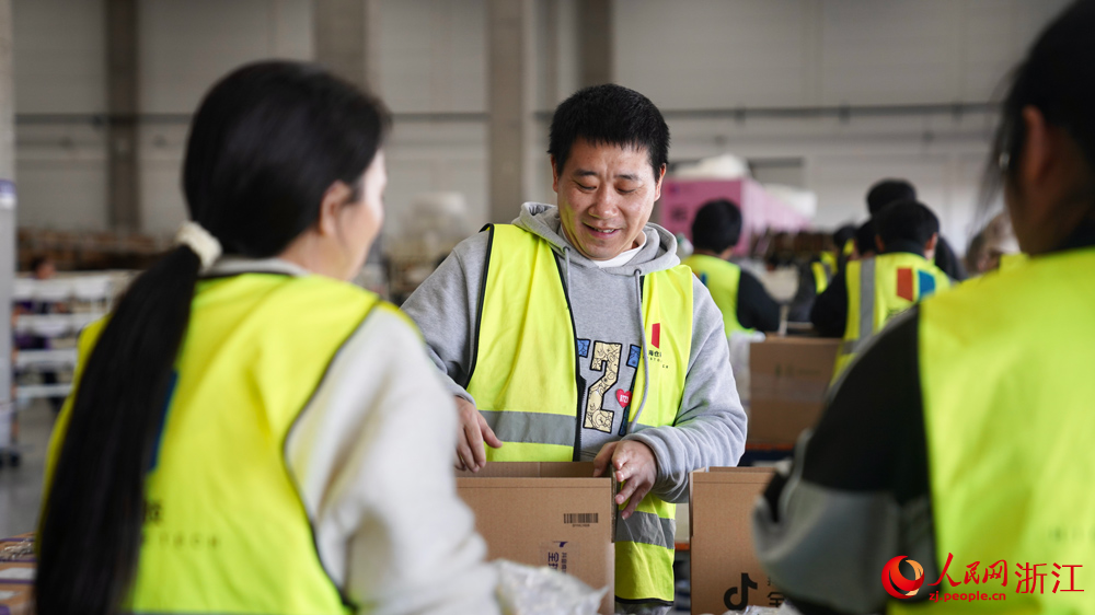 进口商品仓库中，工作人员正忙着检验、分拣、打包进口产品。人民网记者 郭扬摄