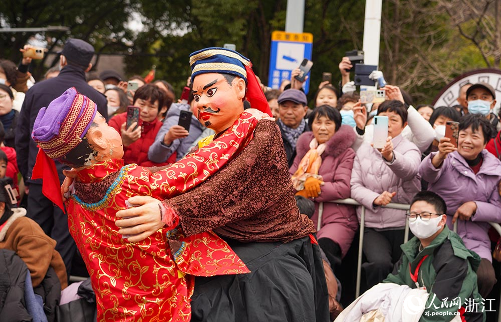 2月11日，在浙江省余姚市，木偶摔跤表演引得市民围观。人民网 章勇涛摄